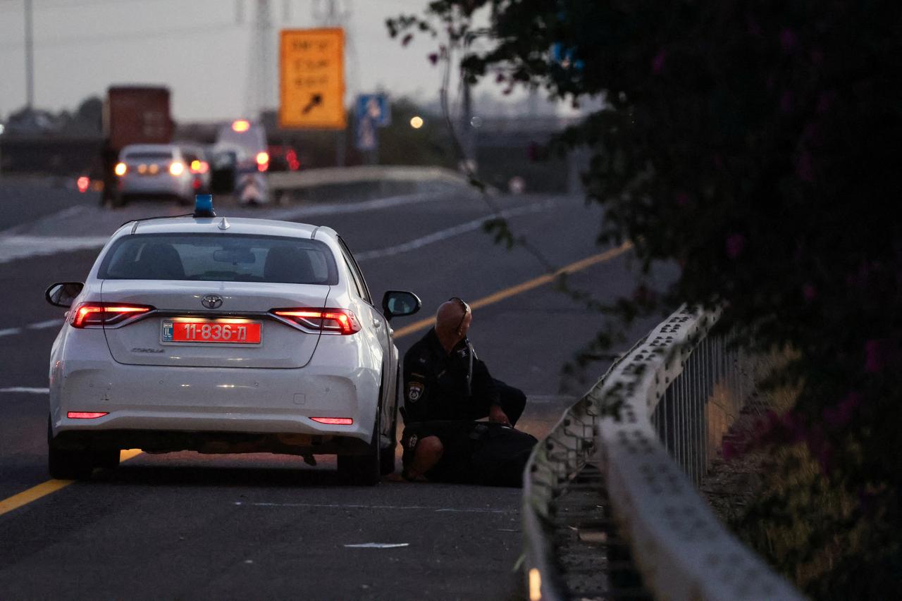 Des policiers s'abritent alors que les sirènes d'alarme retentissent en Israël. [REUTERS - Ronen Zvulun]