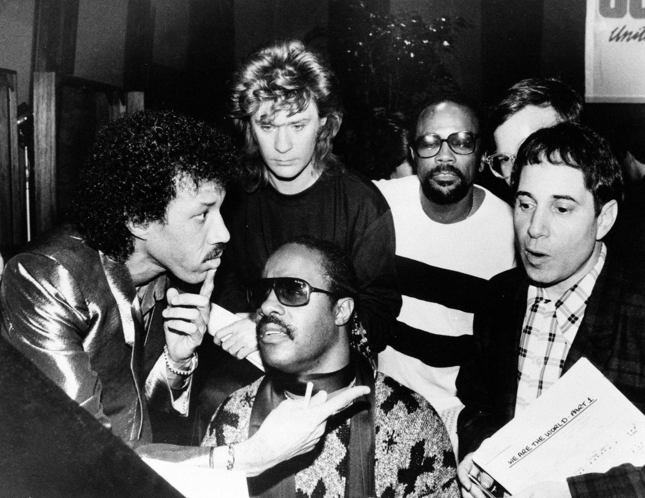 Lionel Richie, Daryl Hall, Quincy Jones, Paul Simon et Stevie Wonder pendant l'enregistrement de "We Are The World" en 1985. [Keystone]