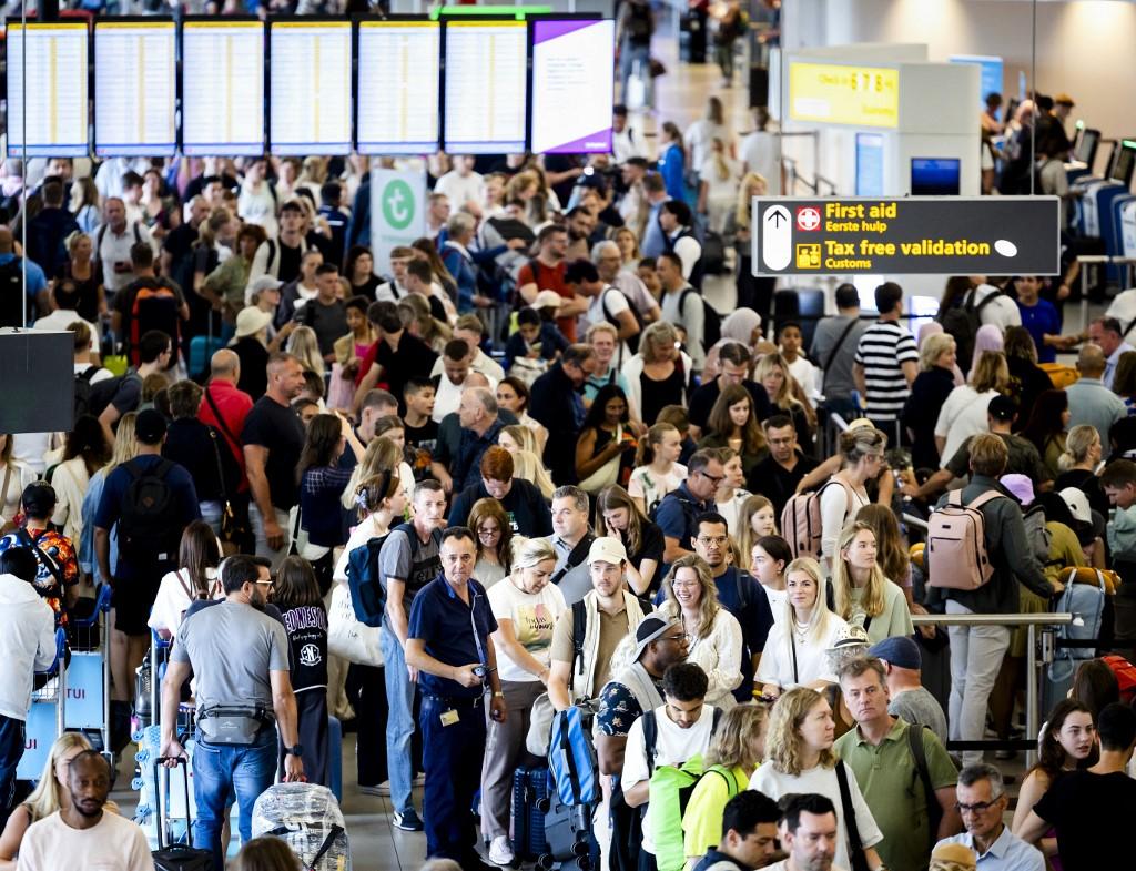 De longues files d'attente se sont formées aux guichets d'enregistrement dans un hall de l'aéroport d'Amsterdam. [ANP via AFP - SEM VAN DER WAL]