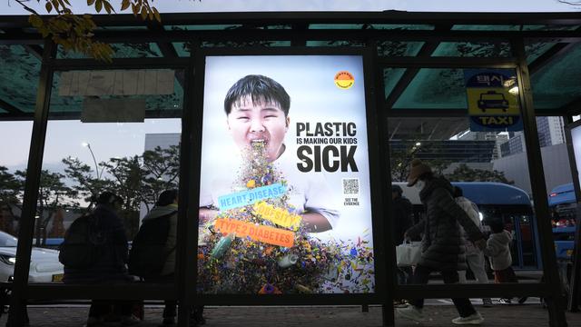 Une affiche avec un appel à la réduction de la production de plastique lors de la 5e session du Comité intergouvernemental de négociation sur la pollution plastique. Busan, Corée du Sud, le 30 novembre 2024. [Keystone/AP photo - Ahn Young-joon]