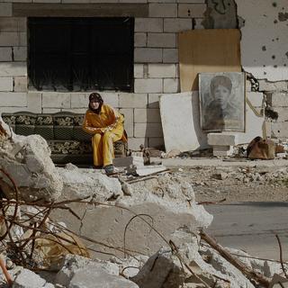 A young woman sits outside her bombed-out house in the village of Zibnine in south Lebanon on Friday, Dec. 22, 2006. Many villagers whose houses were damaged by Israeli airstrikes during this summer's Israel-Hezbollah war are struggling with the cold weather and lack of aids, living in houses that seem on the verge of collapse. [AP Photo/Keystone - Petros Giannakouris]