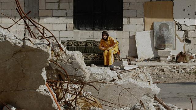 A young woman sits outside her bombed-out house in the village of Zibnine in south Lebanon on Friday, Dec. 22, 2006. Many villagers whose houses were damaged by Israeli airstrikes during this summer's Israel-Hezbollah war are struggling with the cold weather and lack of aids, living in houses that seem on the verge of collapse. [AP Photo/Keystone - Petros Giannakouris]