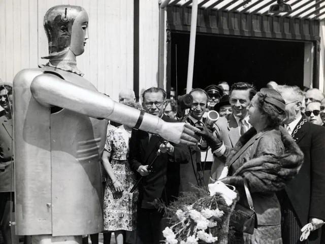 Le robot Sabor d'Appenzell offre des fleurs à la reine néerlandaise Juliana, en 1955. [Zeughaus Teufen]