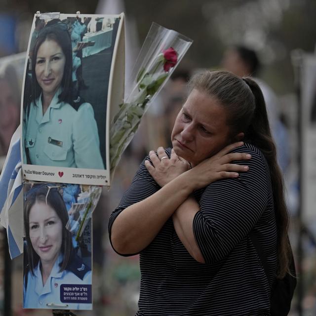 Victoria stands in front a picture of her sister, Yulia Waxer Daunt, as she visits the site of the Nova music festival, where hundreds of revelers were killed and abducted by Hamas and taken into Gaza, on the one-year anniversary of the attack, near Kibbutz Reim, southern Israel, Monday, Oct. 7, 2024. (AP Photo/Ariel Schalit)