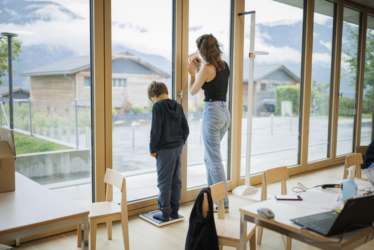 Un élève de l'école primaire de Chamoson est pesé. [KEYSTONE - VALENTIN FLAURAUD]