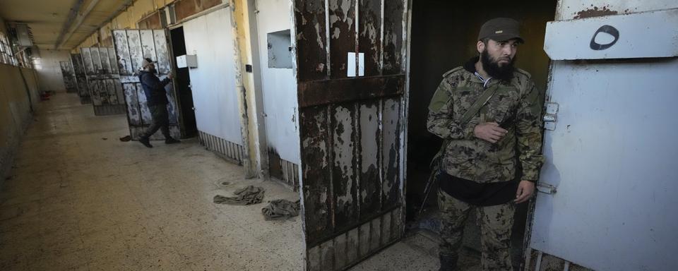 Des combattants rebelles syriens inspectent les cellules de la prison de Saydnaya, au nord de Damas, lundi 9 décembre 2024. [Keystone - Hussein Malla / AP]