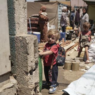 Des enfants palestiniens évacuent une école qui était leur refuge des bombes à Gaza. [Keystone/AP Photo - Abdel Kareem Hana]