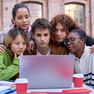 Des jeunes étudiants face à un ordinateur. [Depositphotos - Carlos Baquero]