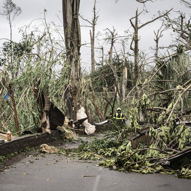 Des secouristes nettoyant une rue de l'archipel de Mayotte, après que le cyclone Chido ait frappé le territoire. [Securite Civile via AP/Keystone - UIISC7]