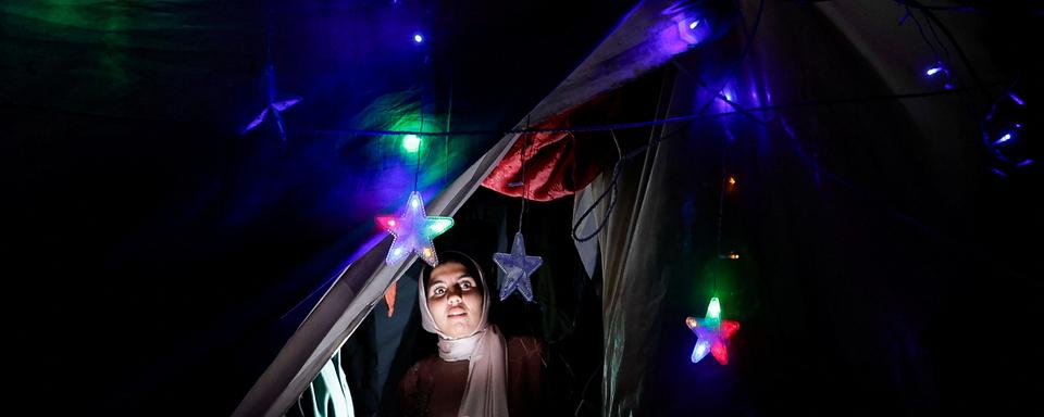 A woman looks on as displaced Palestinians prepare their tents for Ramadan, amid the ongoing conflict between Israel and the Palestinian Islamist group Hamas, in Rafah, in the southern Gaza Strip March 9, 2024. REUTERS/Mohammed Salem [reuters - Mohammed Salem]