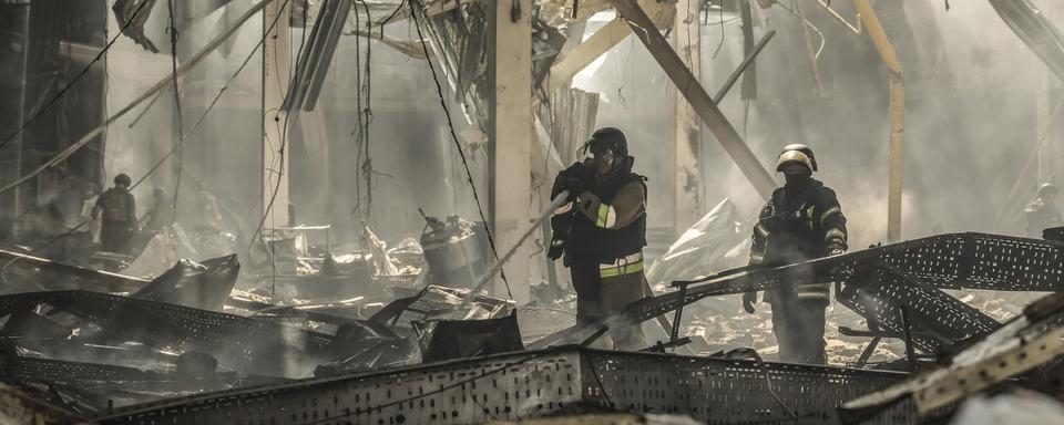 Des sauveteurs ukrainiens travaillent sur le site d'un bombardement russe sur un centre commercial à Kostiantynivka, dans la région de Donetsk, en Ukraine, le 9 août 2024. [Keystone]