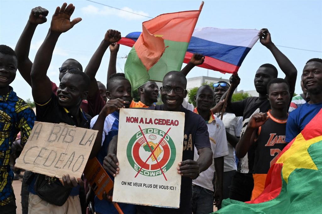 Des manifestants, équipés de pancartes anti-Cedeao et de drapeaux russe et burkinabè, à Ouagadougou, le 4 octobre 2022. [AFP - Issouf Sanogo]