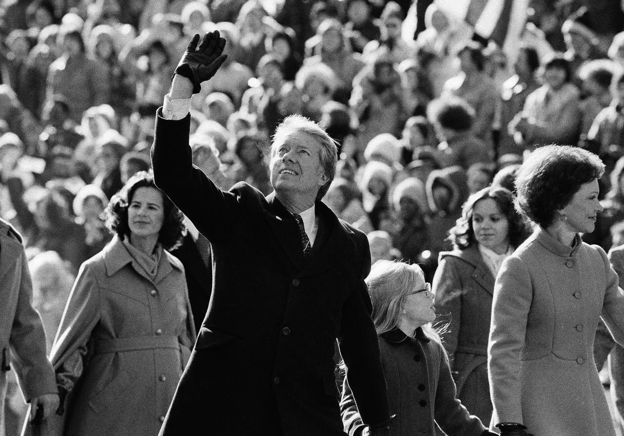 Le président Jimmy Carter prend la route de la Maison Blanche accompagné de son épouse Rosalynn, le 20 janvier 1977, jour de son investiture comme 39e président des Etats-Unis. [KEYSTONE - SUZANNE VLAMIS]