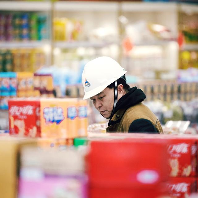 Un ouvrier chinois qui fait des courses à Shangai. [Keystone/EPA - Alex Plavevski]
