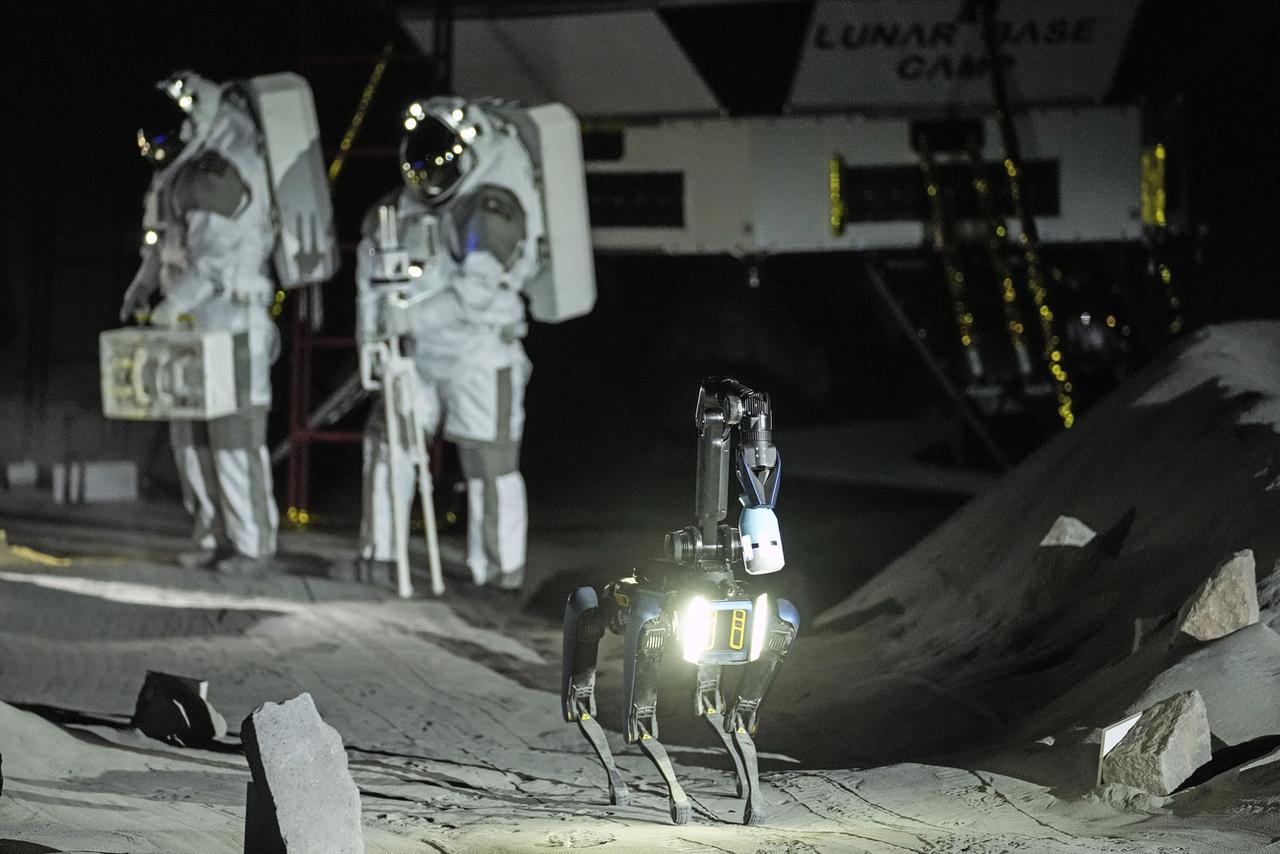 Les astronautes Thomas Pesquet et Matthias Maurer et leur robot canin lors d'une démonstration dans les conditions de simulation de la surface lunaire, lors de l'ouverture de la nouvelle installation LUNA à l'Union européenne Centre des astronautes, près de Cologne, le mercredi 25 septembre 2024. [KEYSTONE - MARTIN MEISSNER]