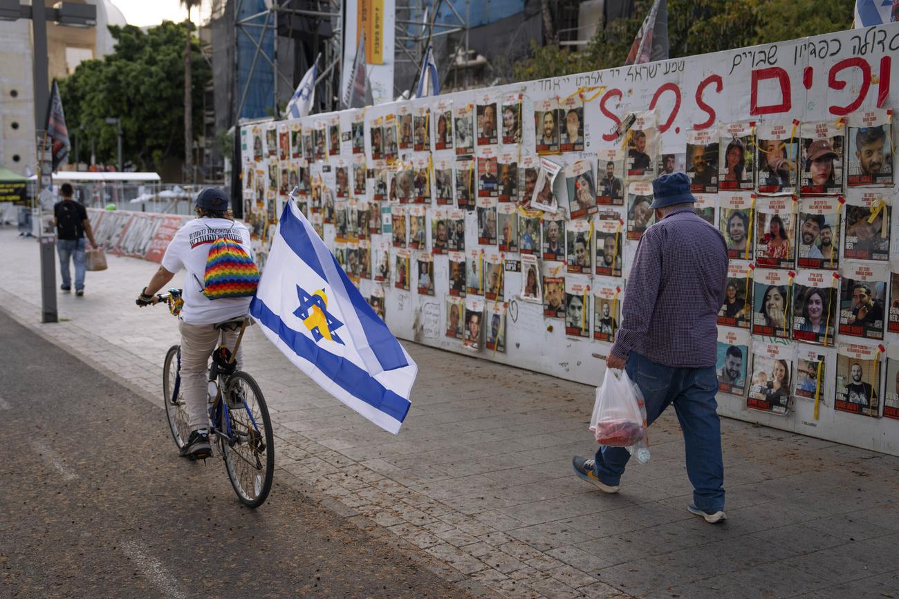 Les photos des otages sont affichées sur un mur de Tel Aviv. [KEYSTONE - ODED BALILTY]