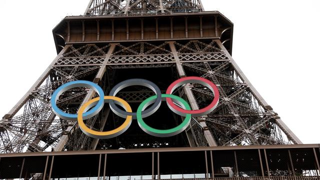 Les anneaux olympiques sont exposés sur la tour Eiffel avant la cérémonie d'ouverture des Jeux Olympiques de Paris 2024, à Paris, le 25 juillet 2024. [Keystone]