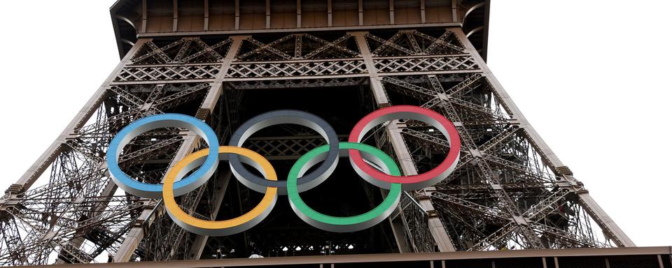 Les anneaux olympiques sont exposés sur la tour Eiffel avant la cérémonie d'ouverture des Jeux Olympiques de Paris 2024, à Paris, le 25 juillet 2024. [Keystone]