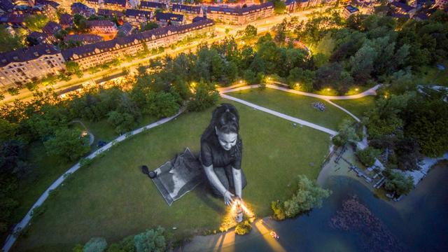 Jeudi 16 mai: une fresque géante mettant en scène une jeune fille entourée de symboles du sauvetage en mer est désormais visible dans un parc à Zurich. L'oeuvre de l'artiste Saype soutient les missions de l'association SOS Méditerrannée visant à sauver des réfugiés en mer. [AFP - GUILLAUME LEGROS]