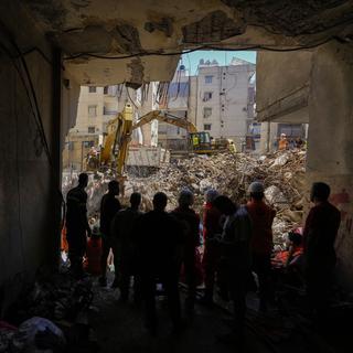 Des sauveteurs près d'un site de tir israélien à Beyrouth. [Keystone/AP Photo - Hassan Ammar]