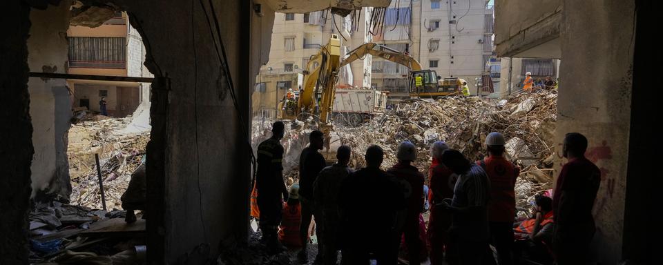 Des sauveteurs près d'un site de tir israélien à Beyrouth. [Keystone/AP Photo - Hassan Ammar]