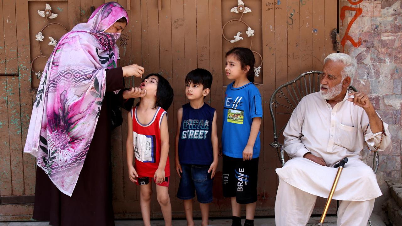 Une travailleuse de santé itinérante vaccine des enfants contre la polio au Pakistan. [Keystone/EPA - Arshad Arbab]