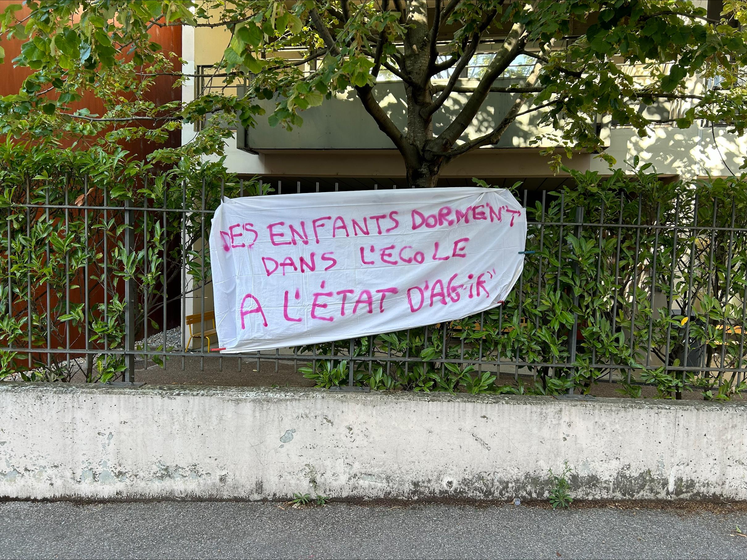 Des banderoles avec le slogan "Les enfants dorment dans l'école, à l'Etat d'agir", sont accrochées pour interpeller l'État. [RTS]