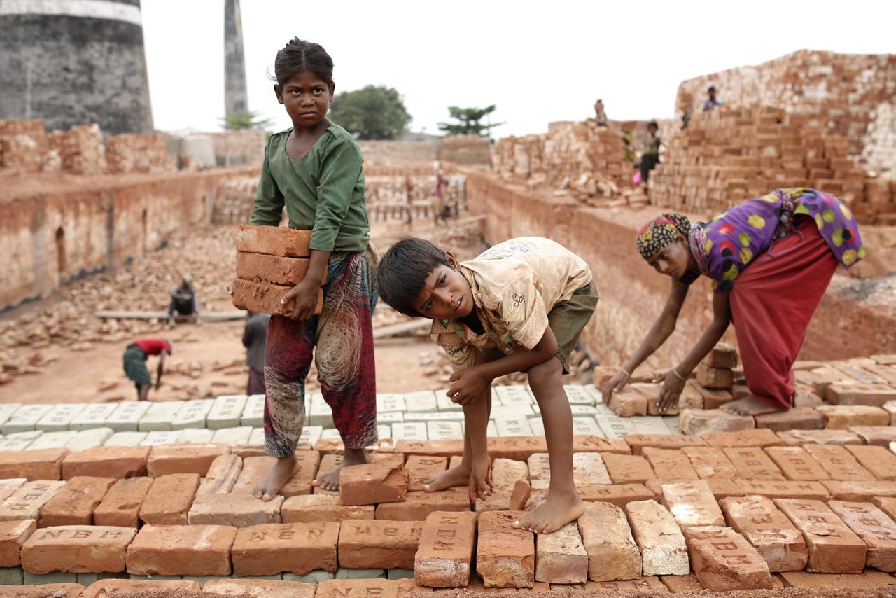 Un garçon de 8 ans et une fille de 11 ans travaillent aux côtés de leur père et de leur mère à Dhaka, au Bangladesh (2016). [KEYSTONE - Abir Abdullah]