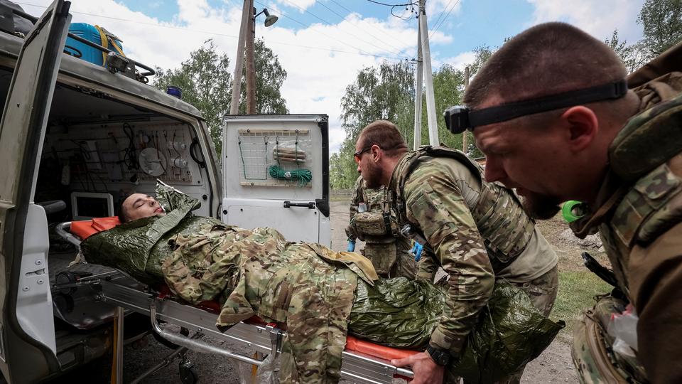 Des ambulanciers paramédicaux militaires transportent un militaire ukrainien blessé, près de la ville de Voltchansk, dans la région de Kharkiv, en Ukraine, le 12 mai 2024. [REUTERS - Vyacheslav Madiyevskyy]