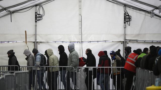 Des migrants et des réfugiés font la queue devant un centre d'enregistrement en Allemagne. [KEYSTONE - MARKUS SCHREIBER]