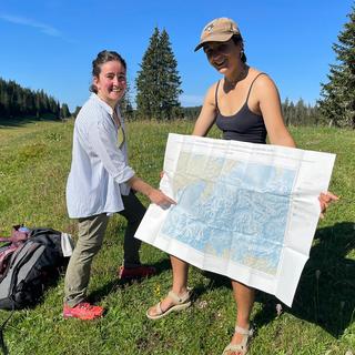 Léa Rodari et Ella Monod, géomorphologues, dans la Combe des Amburnex, en-dessous du Marchairuz, présentent la carte du dernier maximum glaciaire au-dessus de la Suisse (20'000 ans). [RTS - Simon Matthey-Doret]