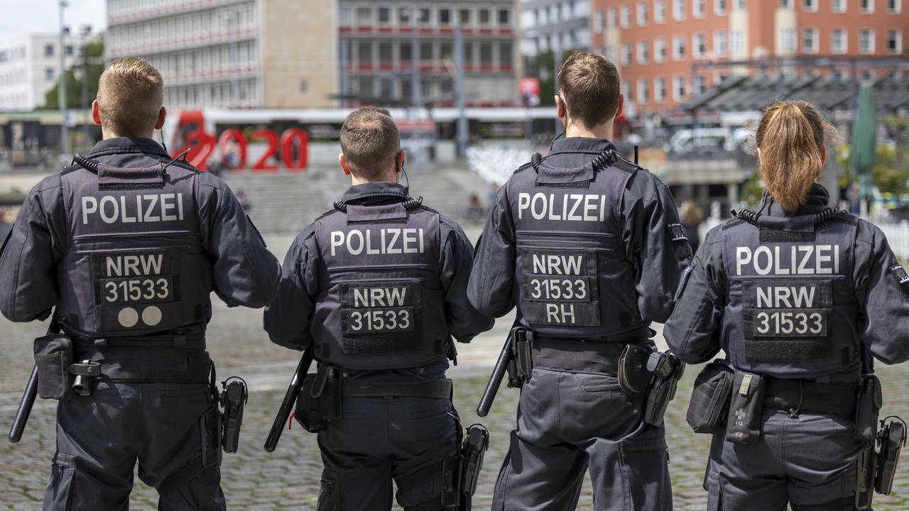 Des agents de la police sont en train de contrôler des personnes sur la Wiener Platz à Cologne. [Keystone/DPA - Thomas Banneyer]