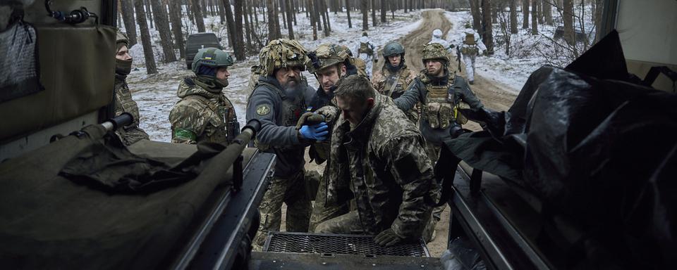 Des médecins militaires en train d'aider un soldat ukrainien. [Keystone/AP Photo - LIBKOS]