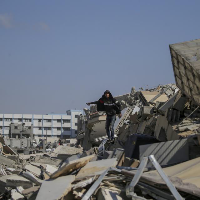 Un homme dans les décombres d'un bâtiment de l'UNRWA. [Keystone/EPA - Mohammed Saber]