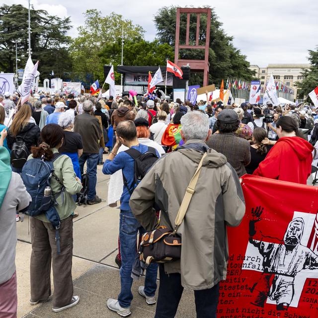 Plusieurs centaines de personnes manifestent devant le siège de l'OMS à Genève contre le traité anti-pandémie qui est en discussion. [Keystone - Salvatore Di Nolfi]