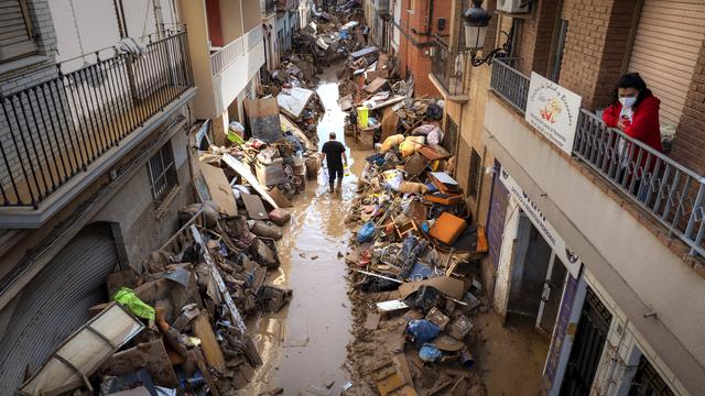 Mardi 5 novembre: A Paiporta, une personne marche dans la rue au milieu des décombres liés aux inondations dans la région de Valence. [Keystone - Emilio Morenatti]