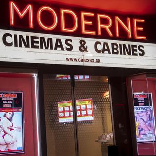 Une vue sur l'entree du cinema pornographique de Lausanne, le "Moderne" au centre ville de Lausanne avec une affiche de l'OFSP pour se proteger contre le nouveau coronavirus le vendredi 13 mars 2020 a Lausanne. Interdictions de reunions de plus de 100 personnes, fermeture de toutes les ecoles, aide d'urgence de 10 milliards pour l'economie et reintroduction des controles a toutes les frontieres. Le Conseil federal a pris vendredi des mesures drastiques contre le coronavirus (Covid-19). [Keystone - Jean-Christophe Bott]