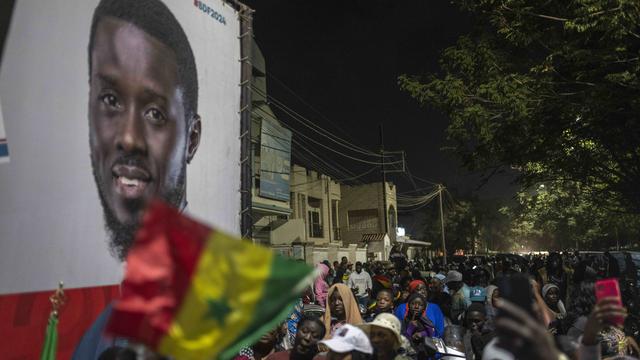 Des partisans de Bassirou Diomaye Faye près du quartier général de l'opposant dans la course à la présidentielle au Sénégal, le 24 mars 2024 à Dakar. [Keystone - Mosa'ab Elshamy]