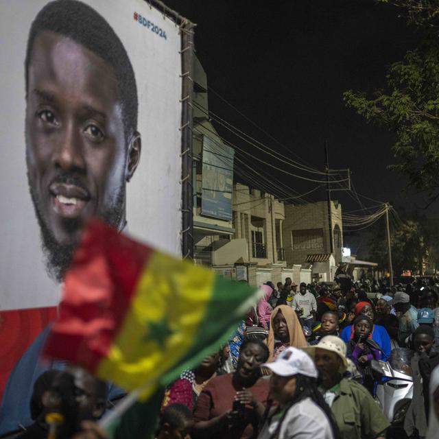 Des partisans de Bassirou Diomaye Faye près du quartier général de l'opposant dans la course à la présidentielle au Sénégal, le 24 mars 2024 à Dakar. [Keystone - Mosa'ab Elshamy]