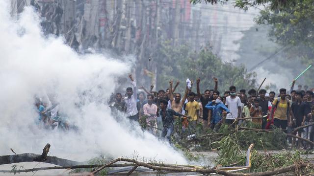 Des étudiants affrontent la police lors d'une manifestation contre le système de quotas dans la fonction publique, à Dhaka, au Bangladesh. [KEYSTONE - RAJIB DHAR]