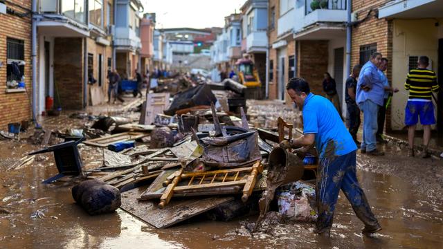 Une habitante de Utiel, petite ville près de Valence, nettoie sa maison après les inondations meurtrières qui ont touché la région. [Keystone - Manu Fernandez / AP]