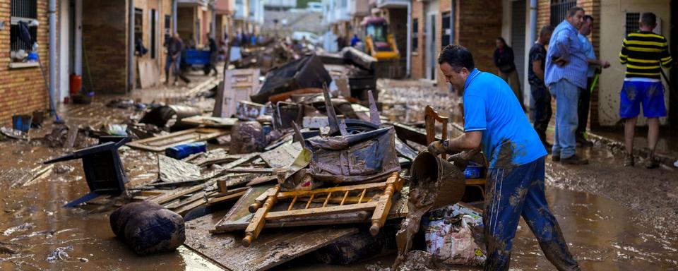 Une habitante de Utiel, petite ville près de Valence, nettoie sa maison après les inondations meurtrières qui ont touché la région. [Keystone - Manu Fernandez / AP]