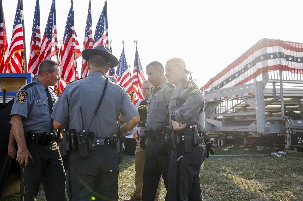 Des agents des forces de l'ordre se tiennent près de l'estrade où se tenait Donald Trump, ancien président et candidat républicain à la présidence, Butler, le 13 juillet 2024. [Getty Images via AFP - ANNA MONEYMAKER]