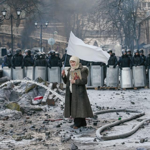Une femme tient un drapeau blanc à Kiev en Ukraine. [Keystone - EPA/Sergey Dolzhenko]