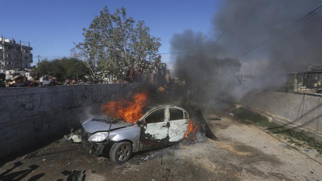 Une voiture brûle après avoir été touchée par une frappe israélienne à Gaza. [Keystone - AP Photo/Hatem Ali]