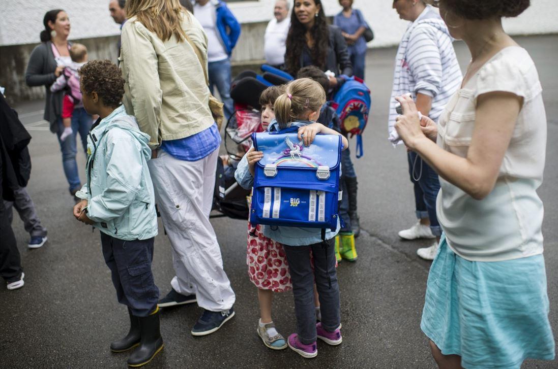 Des enfants accompagnés à l'école par leurs parents. [KEYSTONE - ENNIO LEANZA]