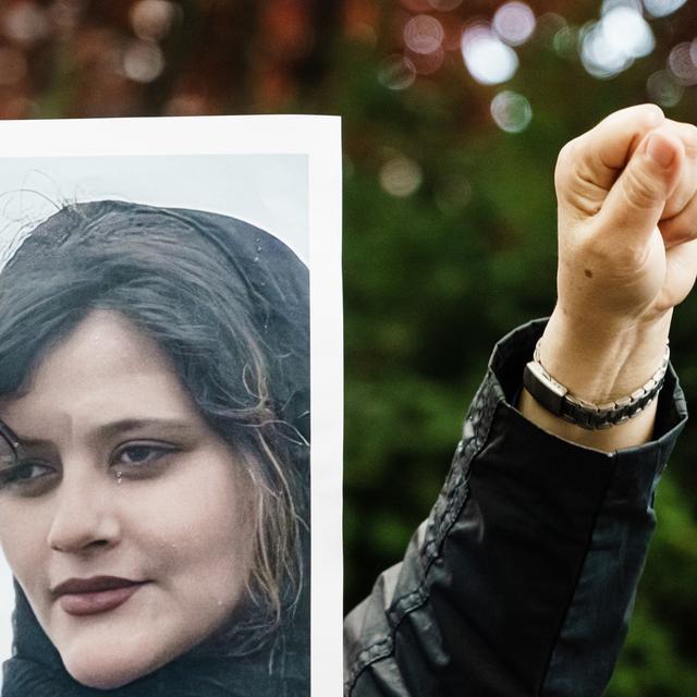 Une personne manifeste contre la République islamique d'Iran avec Mahsa Amini, une femme kurde tuée par la police pour n'avoir pas porté ''correctement'' son voile. [Keystone/EPA - Clemens Bilan]
