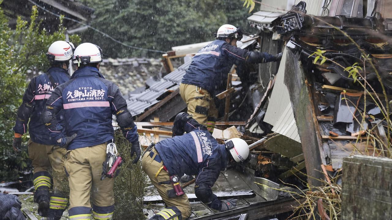 Des pompiers cherchent des survivants après le tremblement de terre au Japon. [Kyodo News via AP]