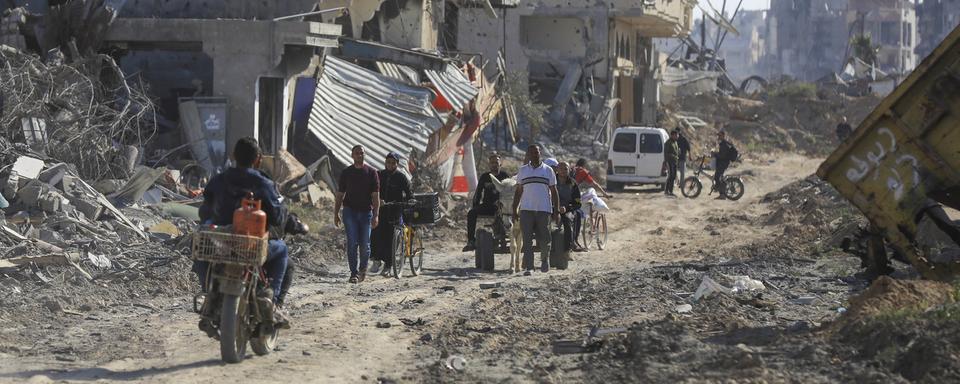 Des Palestiniens marchent parmi les décombres de Khan Younès, après le retrait de l'armée israélienne. [Keystone - Ismael Abu Dayyah / AP Photo]