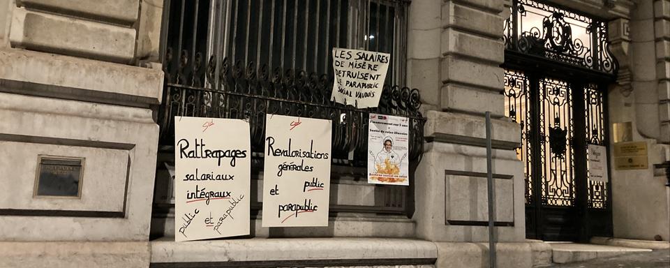 Des affiches de la manifestation des employés des services publics et parapublics vaudois à Lausanne lundi soir. [RTS - Margaux Reguin]